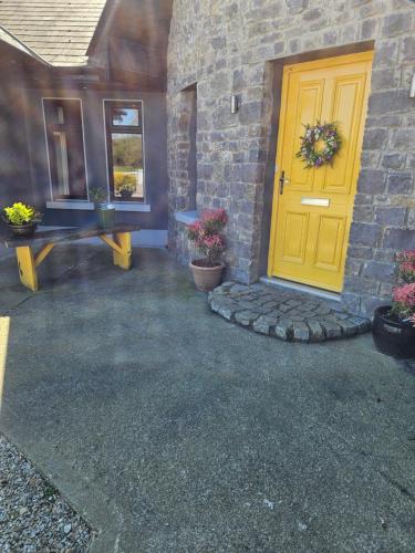 LecarrowArd Aoibhinn Roscommon的石头建筑中带长凳的黄色门
