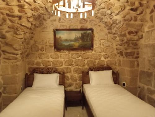 马尔丁ARev BUTİK HOTEL的石墙客房的两张床