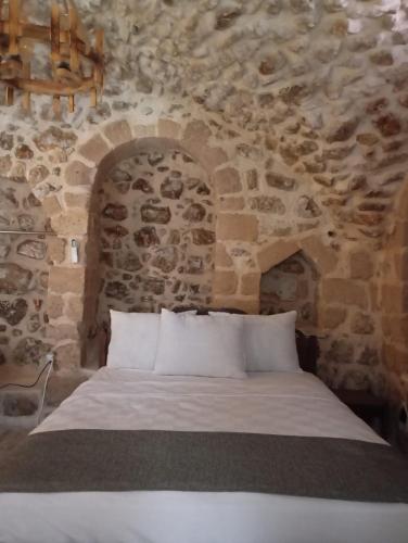 马尔丁ARev BUTİK HOTEL的一间卧室设有石墙和床