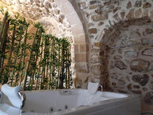马尔丁ARev BUTİK HOTEL的浴室设有石墙内的白色浴缸