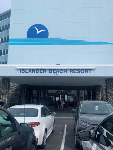 新士麦那海滩Islander Beach Resort by CV的海滩度假村前设有停车场,可停放汽车