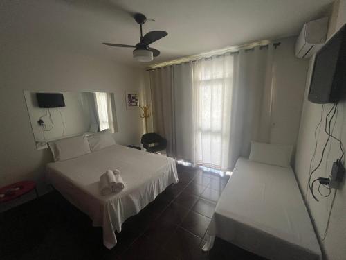 戈亚尼亚Suíte espaçosa! Ar, Tv e banheiro privativo!的酒店客房设有两张床和电视。