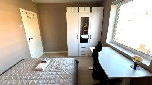 奥斯陆Spacious apartment with free parking的一间卧室配有一张床、一张桌子和一个窗户。