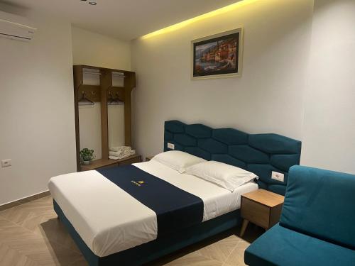 卡萨米尔Agimi Hotel的一间卧室配有一张大床和一张蓝色的沙发
