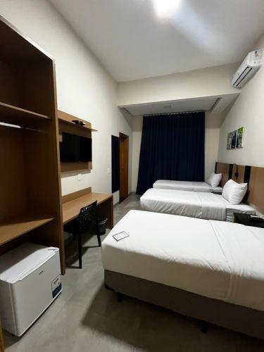 Chapadão do SulSummit Visionsul Hotel的酒店客房配有两张床和一张书桌