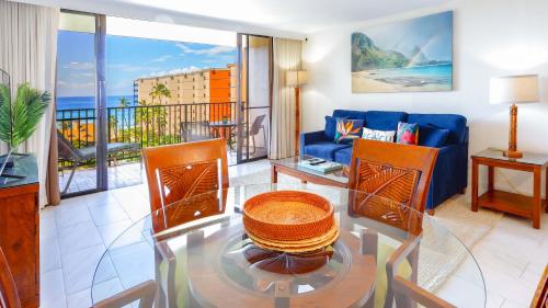 拉海纳Maui Westside Presents: Kaanapali Shores 733 Stunning Ocean Views NEW LISTING的客厅配有蓝色的沙发和玻璃桌