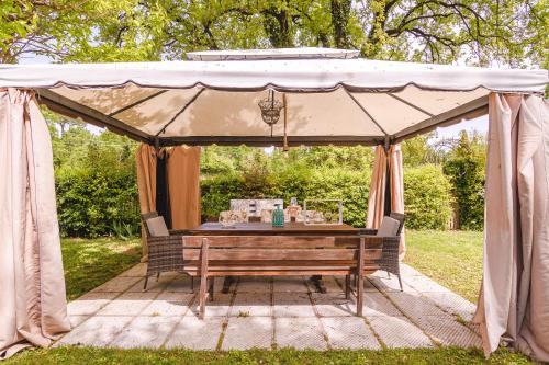 卢奇尼亚诺Il Cerretello - Tuscan Experience的帐篷配有木桌和长凳