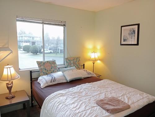 萨里Stylish & Charming Holiday Home - Great Location C3的一间卧室配有一张带两盏灯的床和一扇窗户。