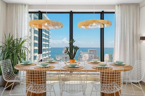 圣胡安HiBird- Apartment and Suites Hotel的一间带桌椅和大窗户的用餐室