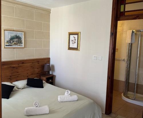 圣朱利安斯绿色树丛旅馆的一间卧室配有一张床,上面有两条毛巾