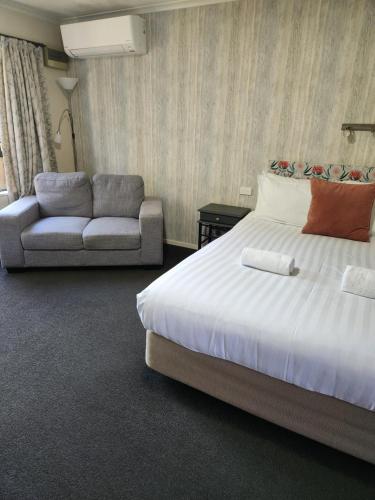 纳尔逊Amber Court Motel Nelson的酒店客房,配有床和沙发