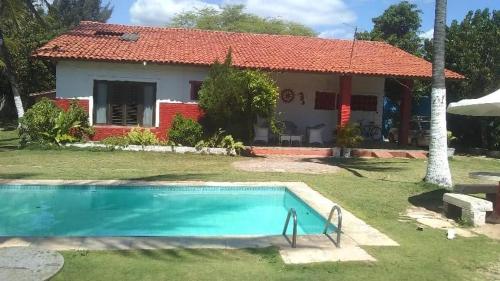 考卡亚Casa de praia Vera的一座房子前面设有游泳池
