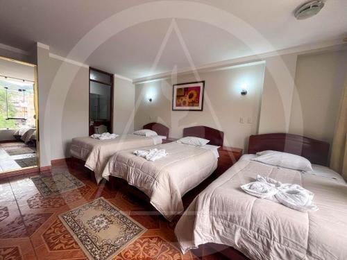 卡哈马卡Retamas Hotel EIRL的一间酒店客房,房间内设有三张床