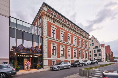 安克拉姆Hotel Anklamer Hof, BW Signature Collection的一座大型砖砌建筑,前面有汽车停放