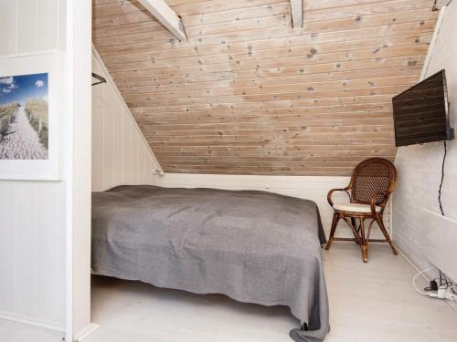 罗莫柯克比Holiday home Rømø XV的一间卧室配有一张床和一把椅子