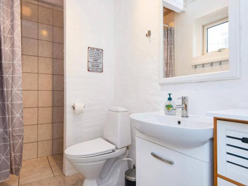 罗莫柯克比Holiday home Rømø XV的白色的浴室设有卫生间和水槽。