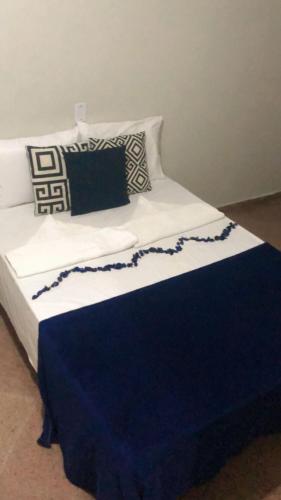 马塞约Pousada Casa Mar Pajuçara的一张带蓝色和白色毯子及枕头的床