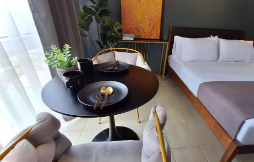 马尼拉The French Apartment Pasig - Fast Wi-Fi and pool的客房设有桌子、床、床和桌椅。