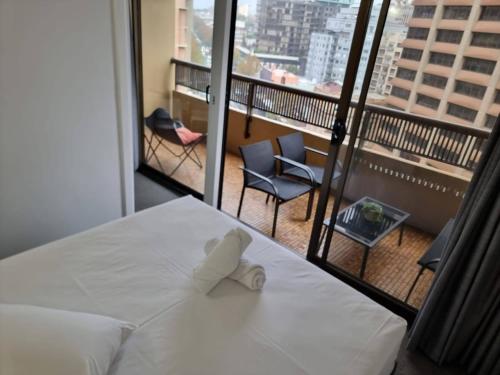 悉尼Accommodation Sydney City Centre 1 Bedroom Apartment with Balcony的酒店客房设有一张床,享有阳台的景色