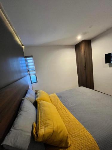 CuauhtémocDepartamento las huertas的一间卧室配有一张带黄色枕头的床