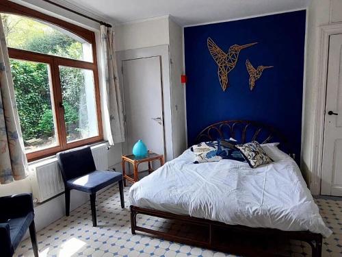 斯帕Heritage Villa in Spa with Garden的一间卧室设有一张床和蓝色的墙壁
