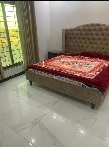 卡拉奇Bahria town karachi的一间卧室配有一张床铺,床上铺有红色毯子