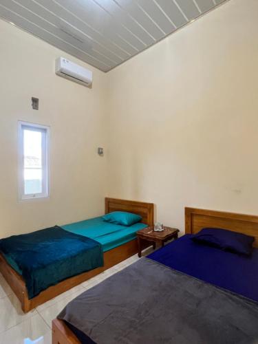 特尔纳特岛KBI Hostel的一间卧室设有两张床和窗户。