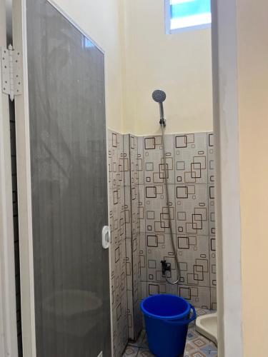 特尔纳特岛KBI Hostel的浴室里设有蓝色水桶淋浴
