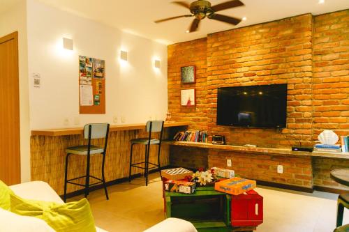 里约热内卢Palace Beach Hostel的客厅设有带凳子和电视的酒吧。