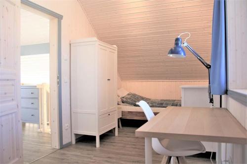 米罗Seeschwalbe Classic 319的客房设有书桌和带台灯的床。