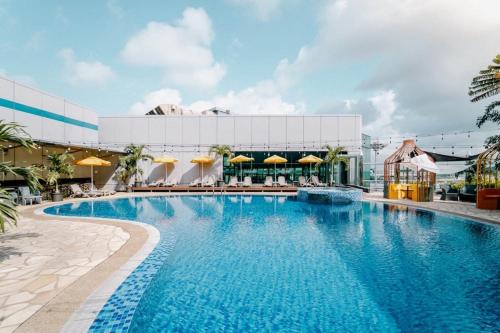 新加坡Aerotel Transit Hotel, Terminal 1 Airside的游泳池,带椅子和遮阳伞