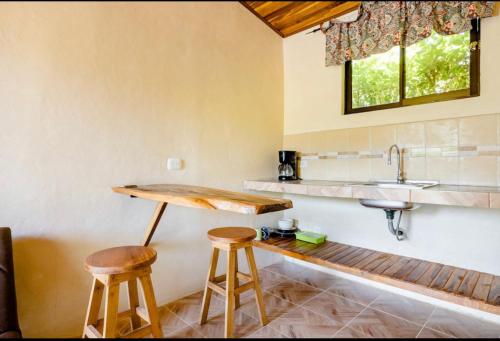 圣克鲁斯Miniapartamento el Guanacaste, cerca Tamarindo的厨房配有2把吧台凳和水槽