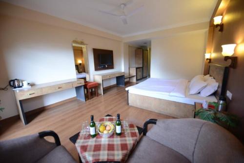 马拉里Goroomgo Park Paradise Manali - Elevator Lift & Parking Facilities的酒店客房配有一张床铺和一张桌子。