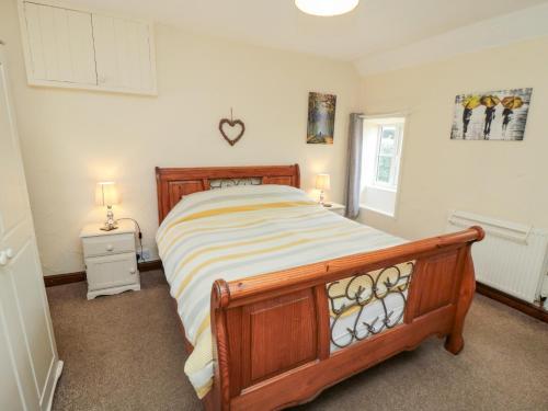 HawskerAbbey View Cottage的一间卧室配有一张床、两盏灯和一个窗户。
