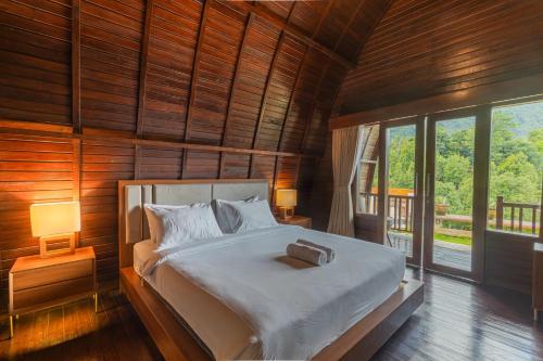 新加拉惹Munduk Kupang Sekumpul Villa的卧室配有一张床铺,位于带木墙的房间内