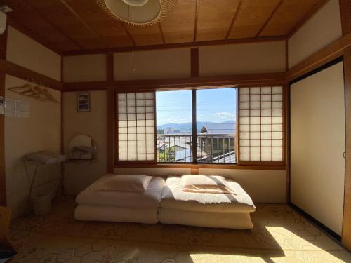 高山Guesthouse Takayama Hanzansha的一间设有床铺的卧室,位于带窗户的房间内