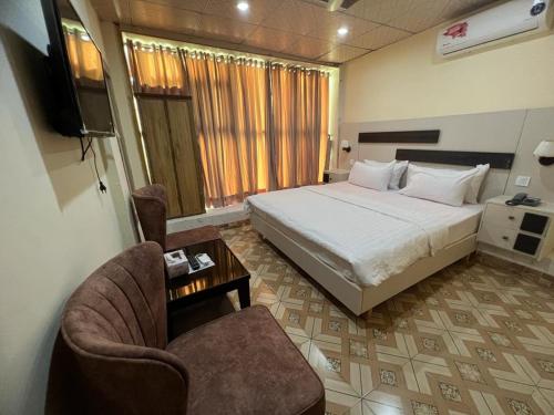 伊斯兰堡Islamabad Premium Hotel的一间卧室配有一张床、一把椅子和电视