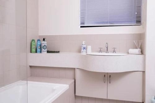 珀斯Exceptional Apt in the heart of Perth City的白色的浴室设有水槽和浴缸。