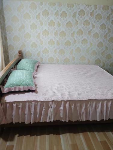 KohīmaAqhe Homestay的卧室内的一张床位,卧室设有墙壁
