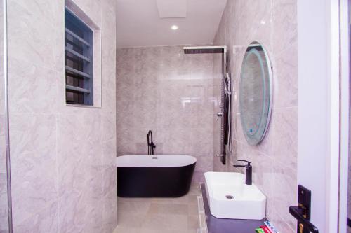 拉各斯Soulmate Hotels & Suites的浴室配有盥洗盆和浴缸。