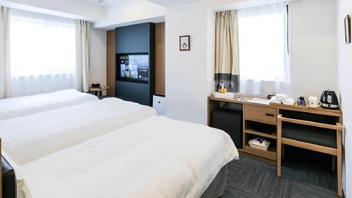 大阪Henn na Hotel Osaka Namba的酒店客房配有两张床和一张书桌