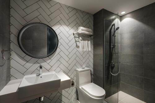 哥打京那巴鲁Citadines Waterfront Kota Kinabalu的一间带水槽、卫生间和镜子的浴室