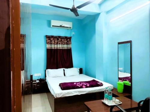 德奥加尔Hotel Ambika的蓝色的客房配有床和镜子