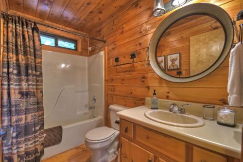 埃利杰Bearfoot Ridge Wood-burning fireplace cozy hot tub serene views的浴室设有卫生间水槽和镜子