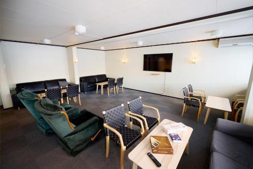 MelhusKarivollen Overnatting的一间配备有桌椅和电视的会议室