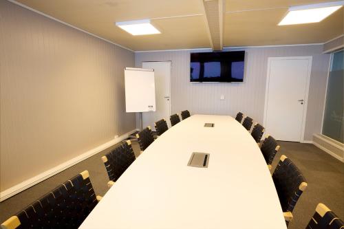 MelhusKarivollen Overnatting的一间会议室,配有长桌子和椅子
