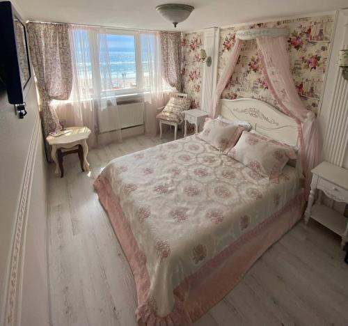 敖德萨萨兰达酒店的一间卧室配有一张粉红色的床和天蓬