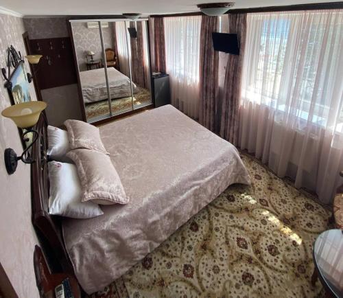 敖德萨萨兰达酒店的一间卧室配有一张床和一面大镜子