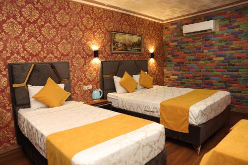 阿达纳阿达纳萨拉伊酒店的酒店客房带两张床和砖墙