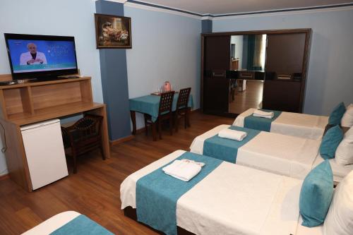 阿达纳阿达纳萨拉伊酒店的一间酒店客房,设有三张床和一台平面电视